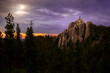 Climber standing on rocky formation in Black Hills top with a gorgeous landscape view of a forest sunset 