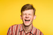 lol lmfao. man laughing hard. joy happiness humor and wide cheerful smile concept. portrait of a young guy on yellow background. emotion facial expression and feelings.