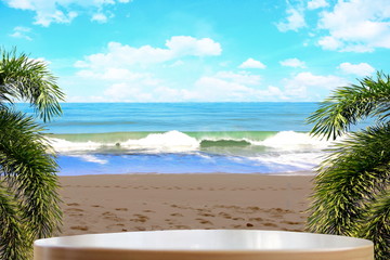 White wooden table on beautiful sea beach mountain cloudy with frame by coconut or palm leaf and bluesky background