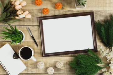 Wood picture frame, diary and coffee with flower decoration on wood background. Rustic nostalgia flat lay.