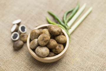 barometer earthstars mushroom in wooden bowl with green chili and lemongrass on hessian texture back