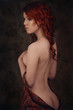 Dramatic retro portrait of a young beautiful dreamy redhead woman. Soft vintage toning.