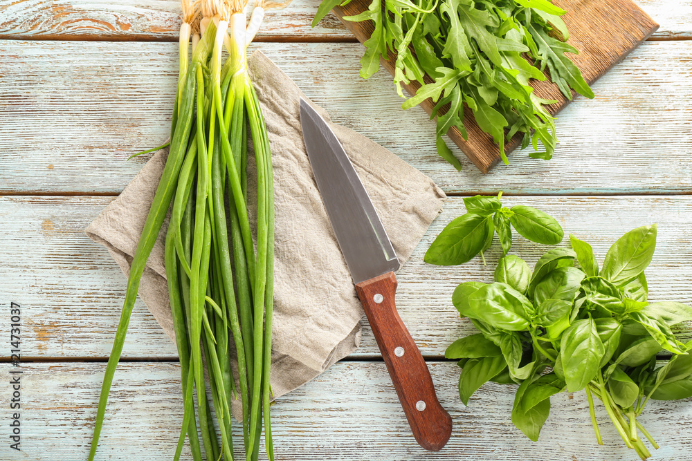 Fresh herbs with knife on wooden background