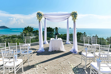 Wall Mural - Wedding venue setting, Arch and altar decorated with roses, flowers, ocean background