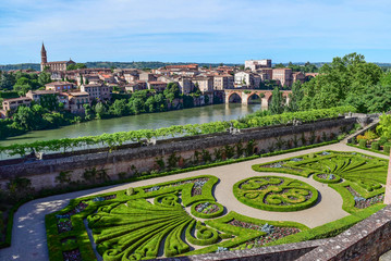 Wall Mural - Panorama of the old city/In the foreground is a beautiful garden, behind it a river with bridges, then city houses and a cathedral.