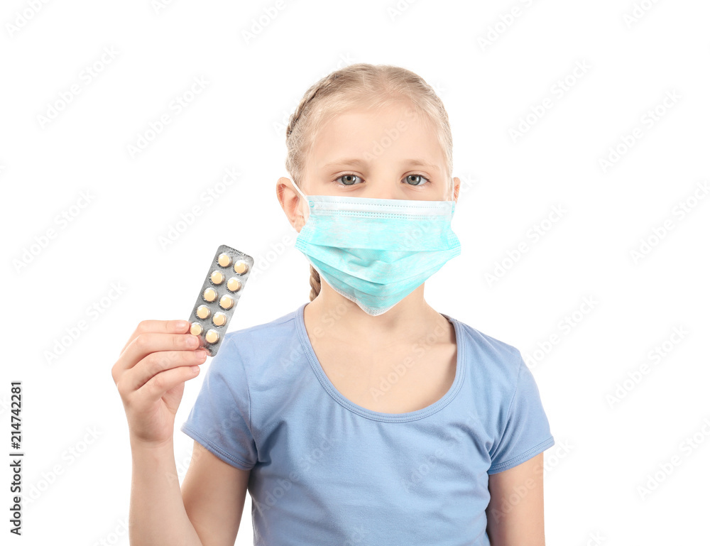 Little girl in protective mask holding pills on white background. Allergy concept