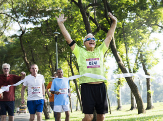 Canvas Print - Happy senior running through the finish line