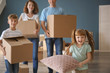 © Pixel-Shot - Happy family with cardboard boxes indoors. Moving into new house
