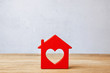 © adragan - Red House with heart, sweet home. Symbol of house on wooden wall on gray wall background
