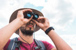 © LIGHTFIELD STUDIOS - handsome male tourist in hat looking in binoculars