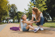© zinkevych - Strong pain. Blonde-haired girl feeling strong pain after falling from skateboard walking with her mother