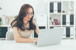 © pixindy - Happy young businesswoman with glasses working on computer laptop in home office