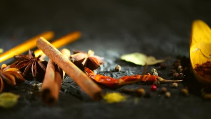 Wall Mural - Spices. Various Indian spices on a dark stone table. Spice and herbs on black background. Dolly shot. 3840X2160 4K UHD video footage