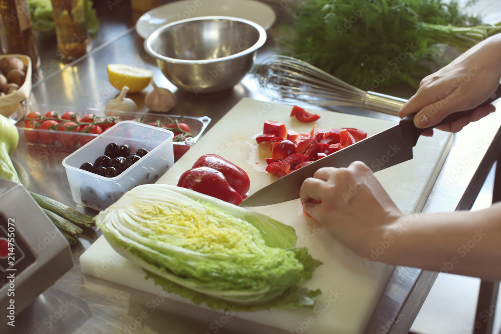 Female chef cutting vegetables in restaurant kitchen