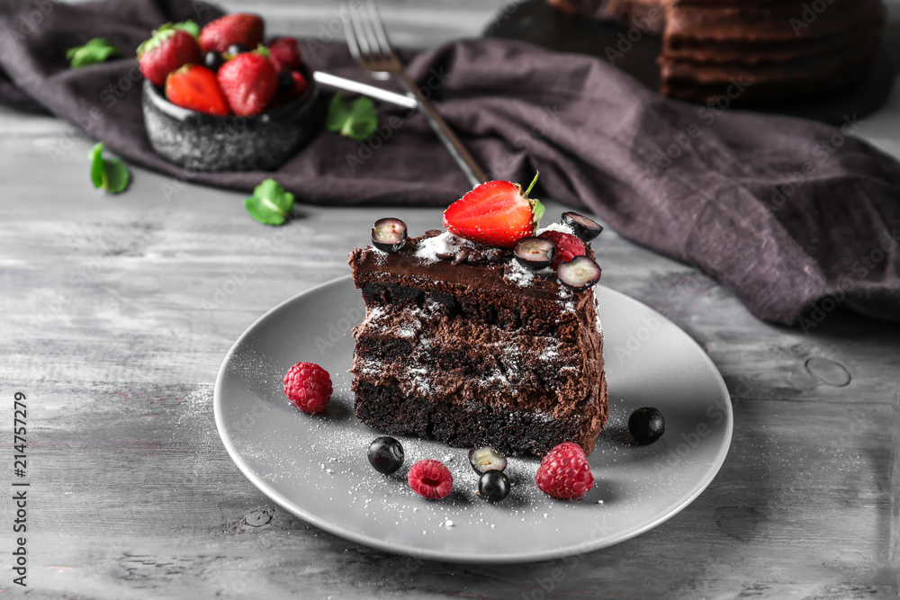 Piece of delicious chocolate cake with berries on plate