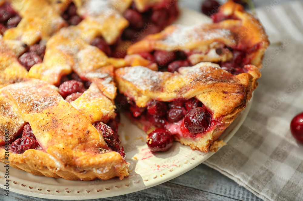 Plate with delicious homemade cherry pie on wooden table, closeup
