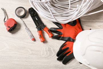 Different electrician's supplies on wooden floor