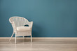 © Pixel-Shot - Comfortable wicker armchair near color wall