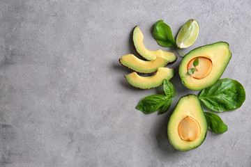 Composition with fresh cut ripe avocados on grey textured background