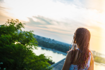 Rear view of teenage girl looking to the sun / Urban sunset scene. Millennial Generation