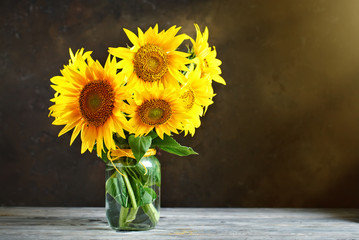 Fotomurales - Beautiful sunflowers in a basket on a wooden table.