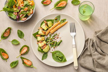 Tasty salads with vegetables and seafood in bowl and plate on table