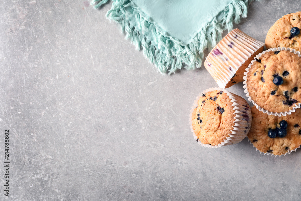 Tasty blueberry muffins on grey background