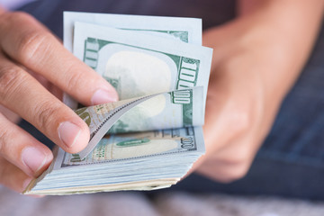 Wall Mural - Close up woman hands holding and counting bunch of America dollars banknotes calculator and red pencil in background.