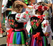 Dziewczynki ubrane w tradycyjne ludowe stroje łowickie podczas corocznej procesji Bożego Ciała w Łowiczu, Polska, w tle tłum uczestników procesji