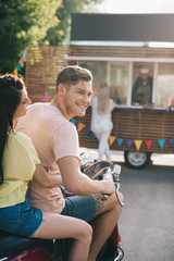 Poster - smiling couple sitting on motorbike near food truck on street