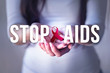 © lordn - Woman holding red ribbon on her palms. AIDS awareness symbol