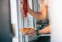 Cropped Image Of Chef Adding Ketchup To Hot Dog In Food Truck