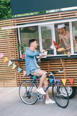 Wall Mural - Chef giving hot dog and ketchup to customer from food truck