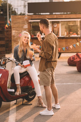 Poster - smiling couple eating french fries and burger near food truck