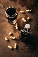 Wall Mural - top view of arranged peanuts, bottle and glass of beer on rust tabletop