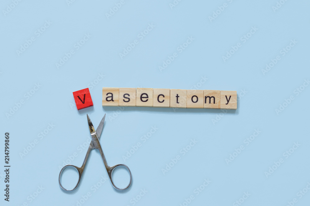 Vasectomy concept: the word vasectomy made with wooden tiles on a blue background; V is red and scissors are under the word - obrazy, fototapety, plakaty 