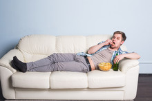 Man With Beer And Chips Watching TV At Home
