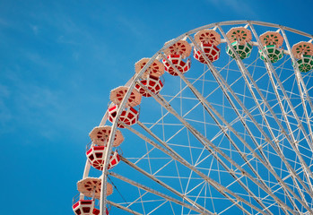 Ferris wheel on blue sky background. In the amusement Park. The weekend