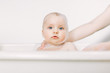 © sofiko14 - Happy laughing baby taking a bath playing with foam bubbles. Little child in a bathtub. Infant washing and bathing.