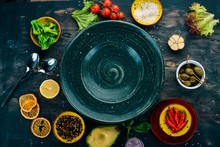 Green Plate On A Wooden Background With Vegetables. On A Wooden Table. Top View. Copy Space.