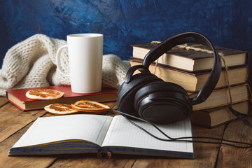 books are stacked, headphones, white cup, orange slices, open di