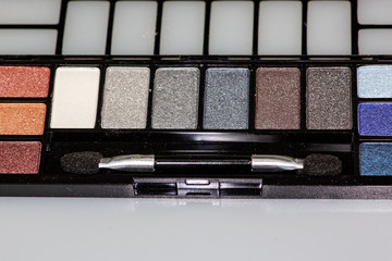 Multi colored eye shadow palette on the counter waiting to be used.