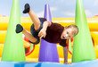 © Augustas Cetkauskas - Child jumping on colorful playground trampoline. Kids jump in inflatable bounce castle on kindergarten birthday party Activity and play center for young child. Little girl playing outdoors in summer.