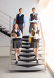© New Africa - Teenage students in stylish school uniform on stairs indoors