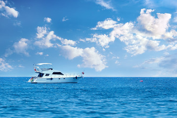 Wall Mural - Yacht in the sea on a background of the sky with clouds.Vacation holiday concept.