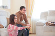 © Aleksei Lazukov - young couple laughing while sitting on sofa in living room