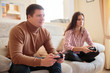 © Aleksei Lazukov - young couple sitting on sofa and playing video game