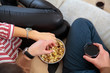 © Aleksei Lazukov - young couple sitting on couch eating popcorn close up