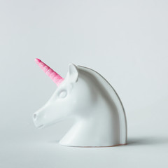 Wall Mural - White painted unicorn head with pink horn on bright white background. Minimal art fantasy concept.