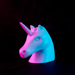 Wall Mural - white painted unicorn head in bold pink and blue neon colors on dark background. minimal art fantasy